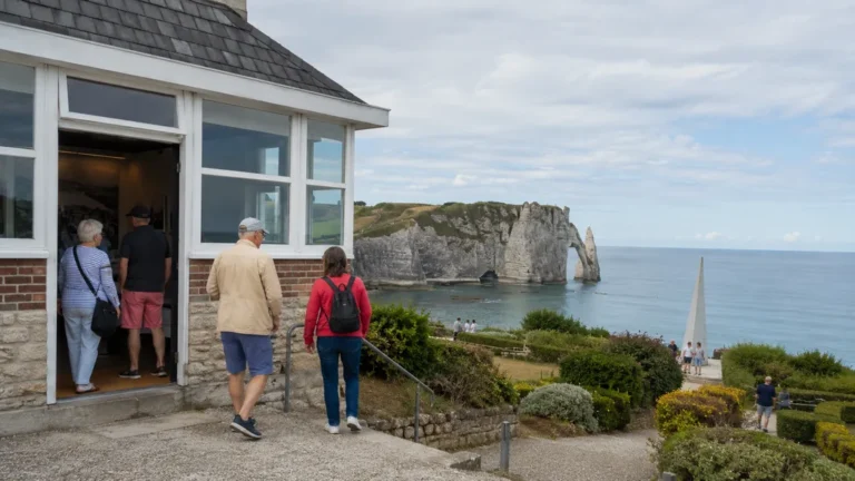 Visiteurs découvrant le Musée du patrimoine d’Étretat sur la falaise d’Amont avec les célèbres falaises en arrière-plan