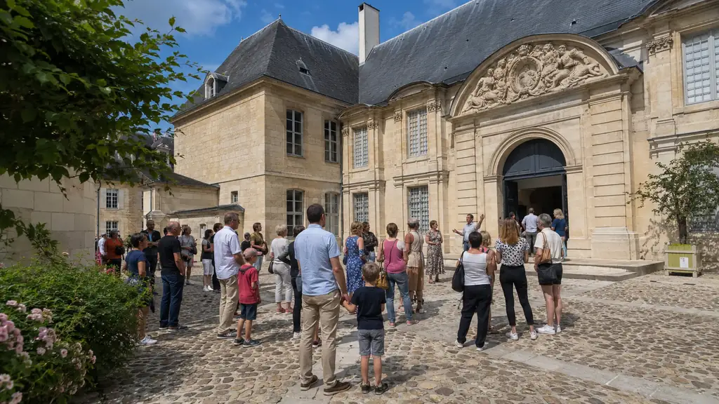 Familles participant à une visite guidée dans la cour d’un monument historique du Val-d’Oise pendant les Journées du patrimoine.