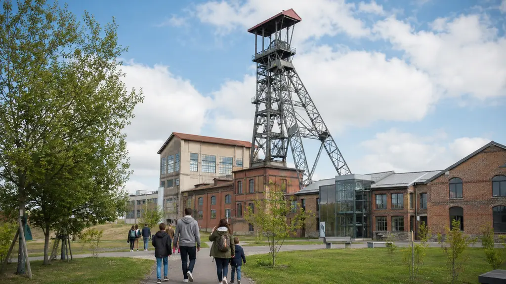 Famille arrivant devant le chevalement et les bâtiments industriels du musée de la Mine de Saint-Étienne